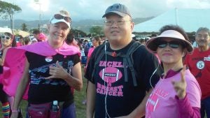 1021170702a Two women and a man smiling wearing pink