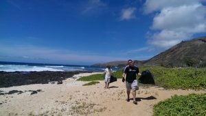 2013-07-13+10.30.30 Two men picking up garbage on a beach