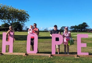 Tyler Hawaii Staff posing in front of the HOPE logo after the cancer walk