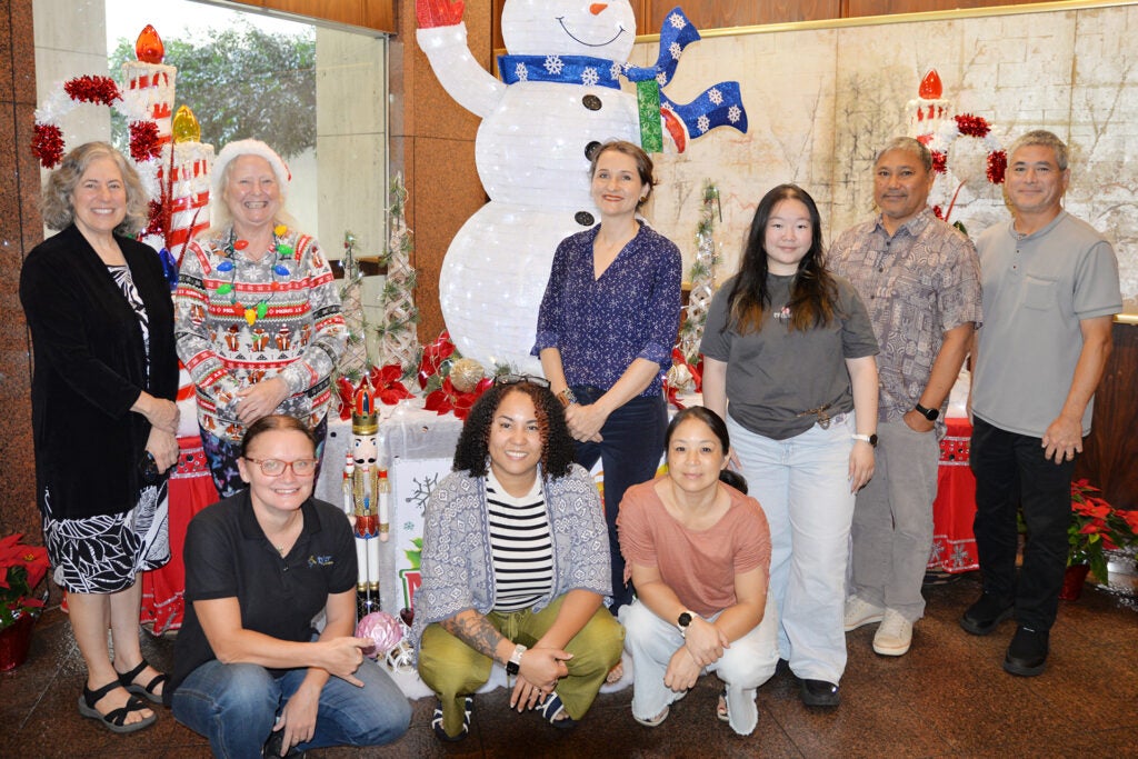 Group photo posed in front of Christmas decor