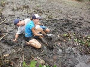Two people playing in the mud