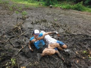 Two people playing in the mud