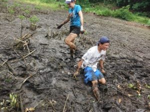 Two people playing in the mud