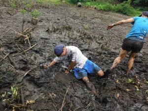 Two people playing in the mud