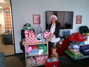 woman in red santa hat holding many presents