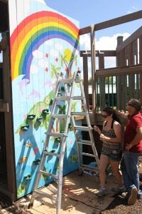 final4 Woman painting a rainbow on a wall