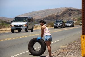 img_0289 Woman holding a tire on side of road