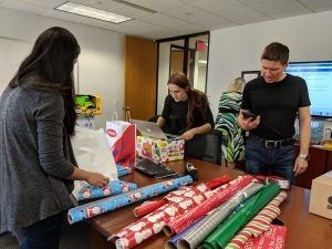 Maker:0x4c,Date:2017-10-11,Ver:4,Lens:Kan03,Act:Lar01,E-ve Three women and a man wrapping gifts