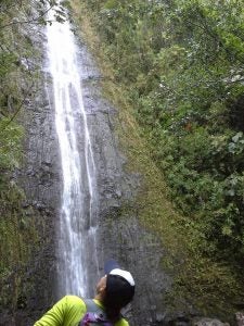 trail1 Woman looking up at a waterfall